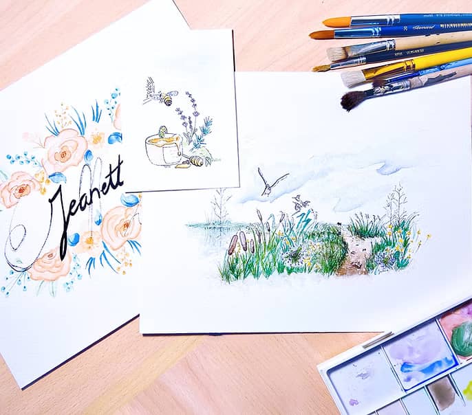 3 aquarelles empilées avec des pinceaux à côté
